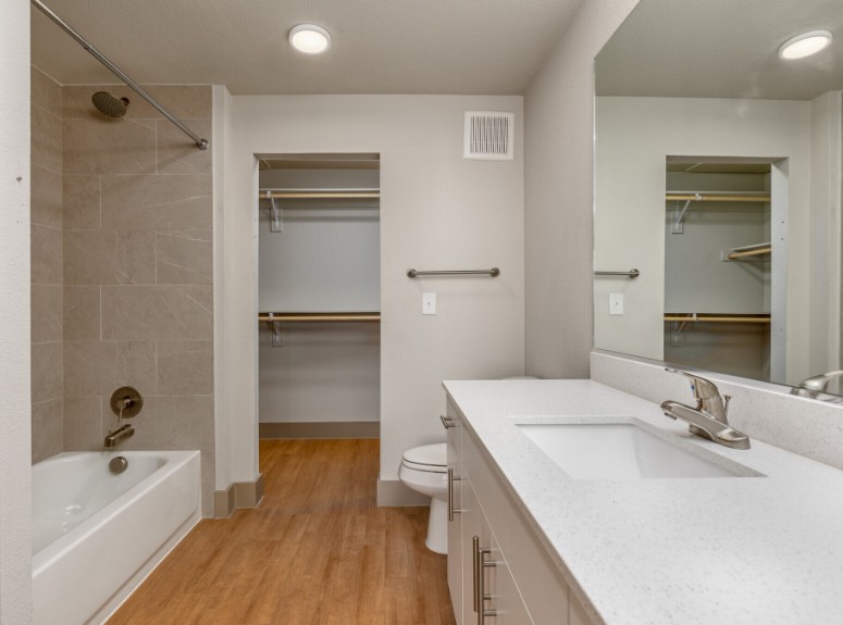 A modern bathroom with a white tub and sink.